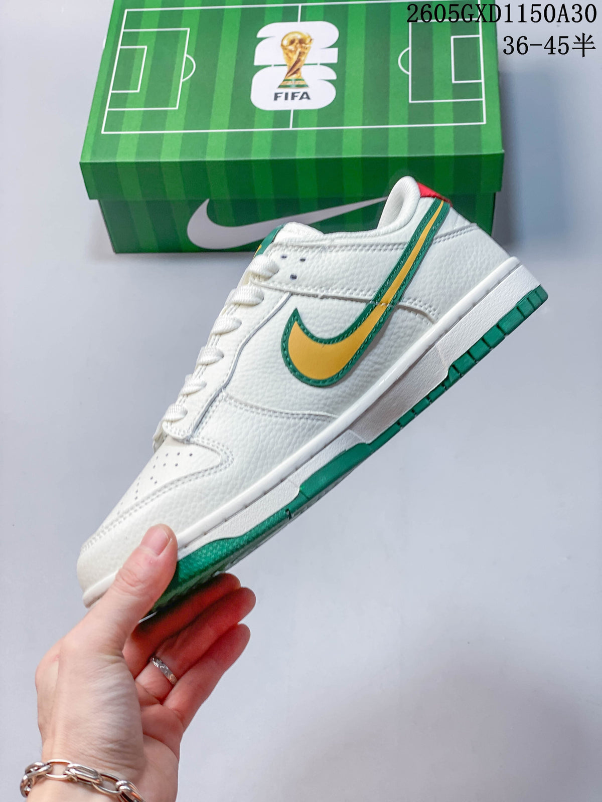 Side profile of the white low-top sneaker with a yellow and green Swoosh and green outsole.