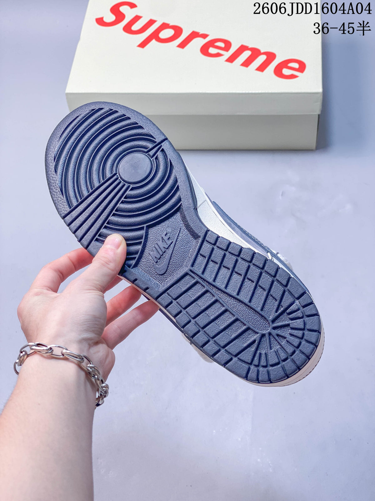 Blue-gray outsole of a Nike SB Dunk Low sneaker with branded box behind it