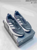 Dark gray Adidas sneakers with light stripes shown beside a white pair with dark stripes and orange accents.