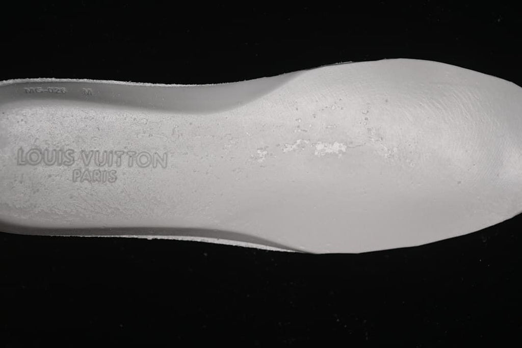 Close-up of the white shoe insole with embossed Louis Vuitton Paris lettering.