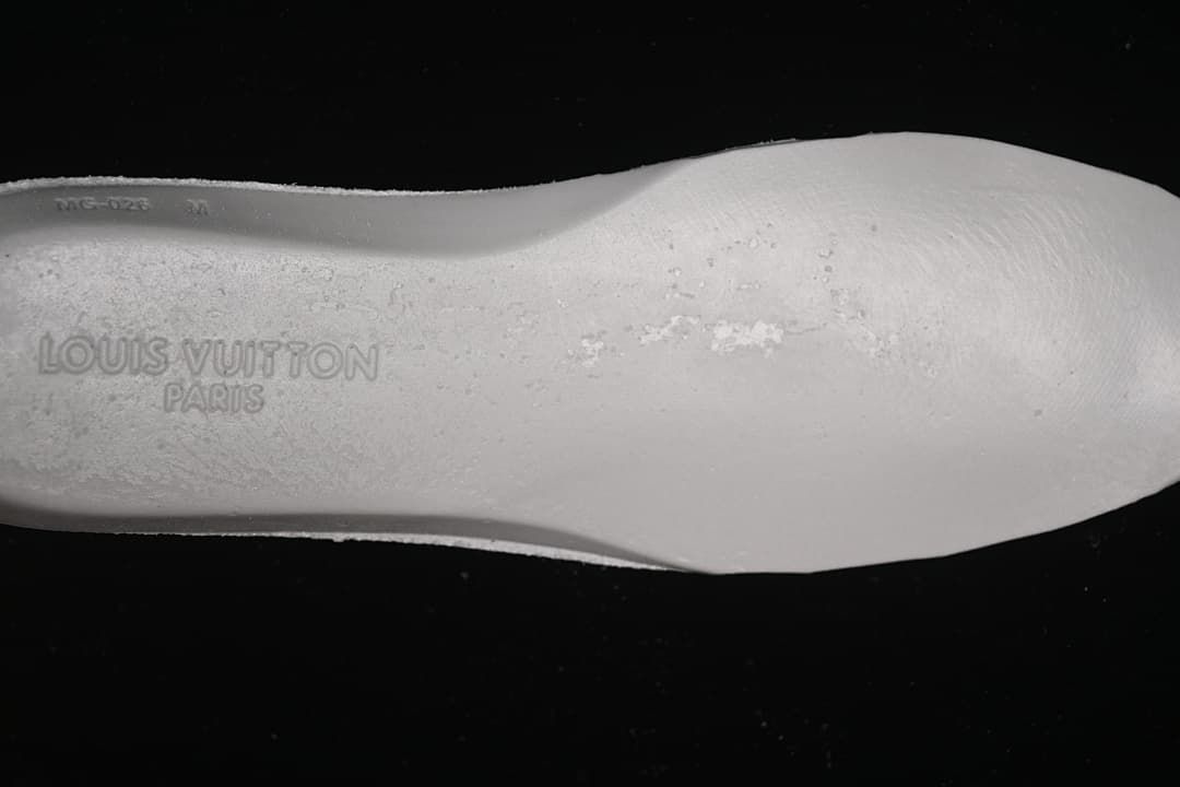Close-up of the white shoe insole with embossed Louis Vuitton Paris lettering.