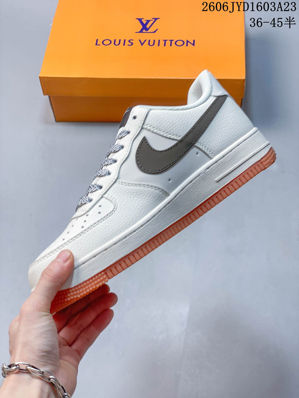 Side view of the off-white low-top sneaker with gray Swoosh and orange outsole