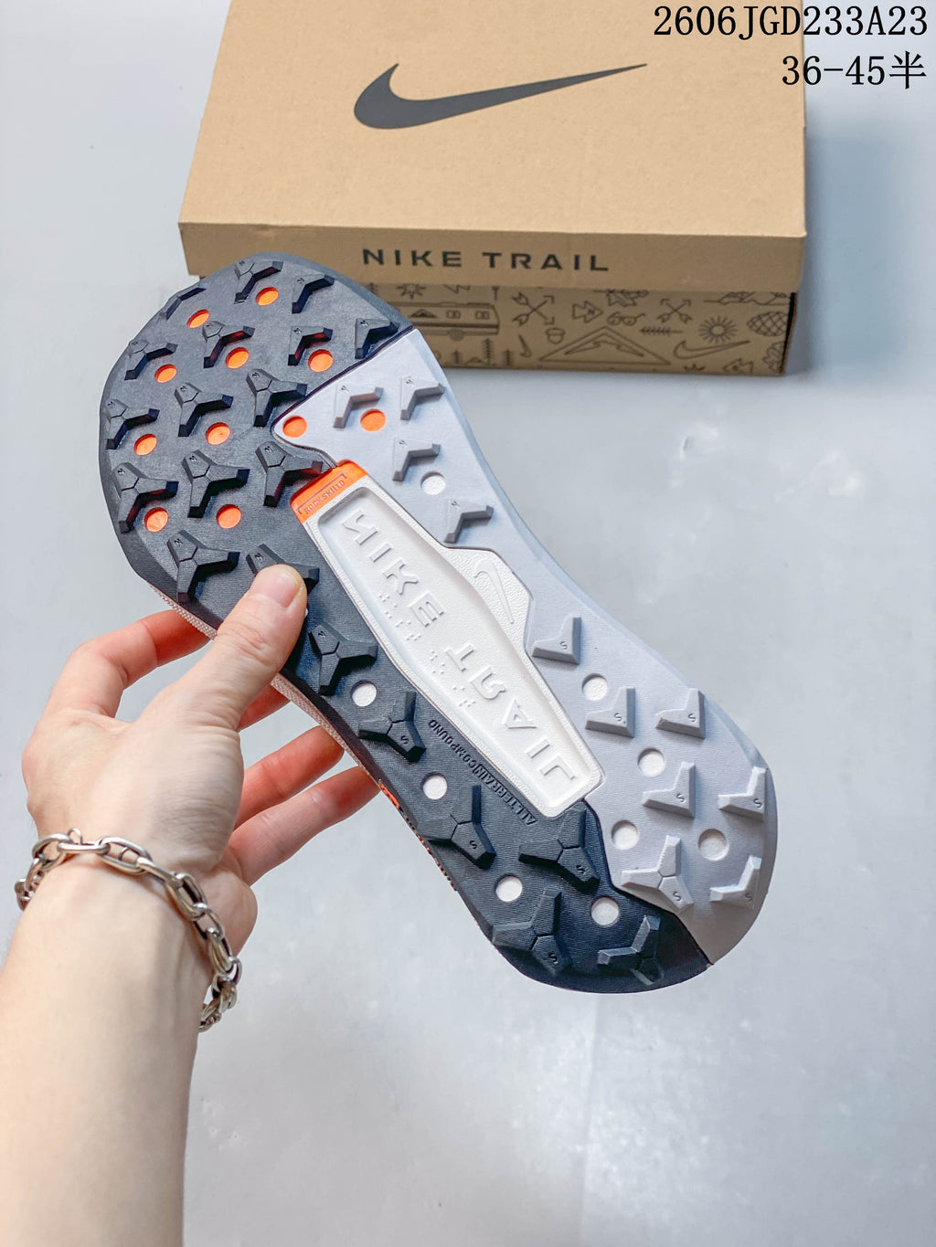 Close-up of the lugged outsole with dark gray, light gray, and orange details