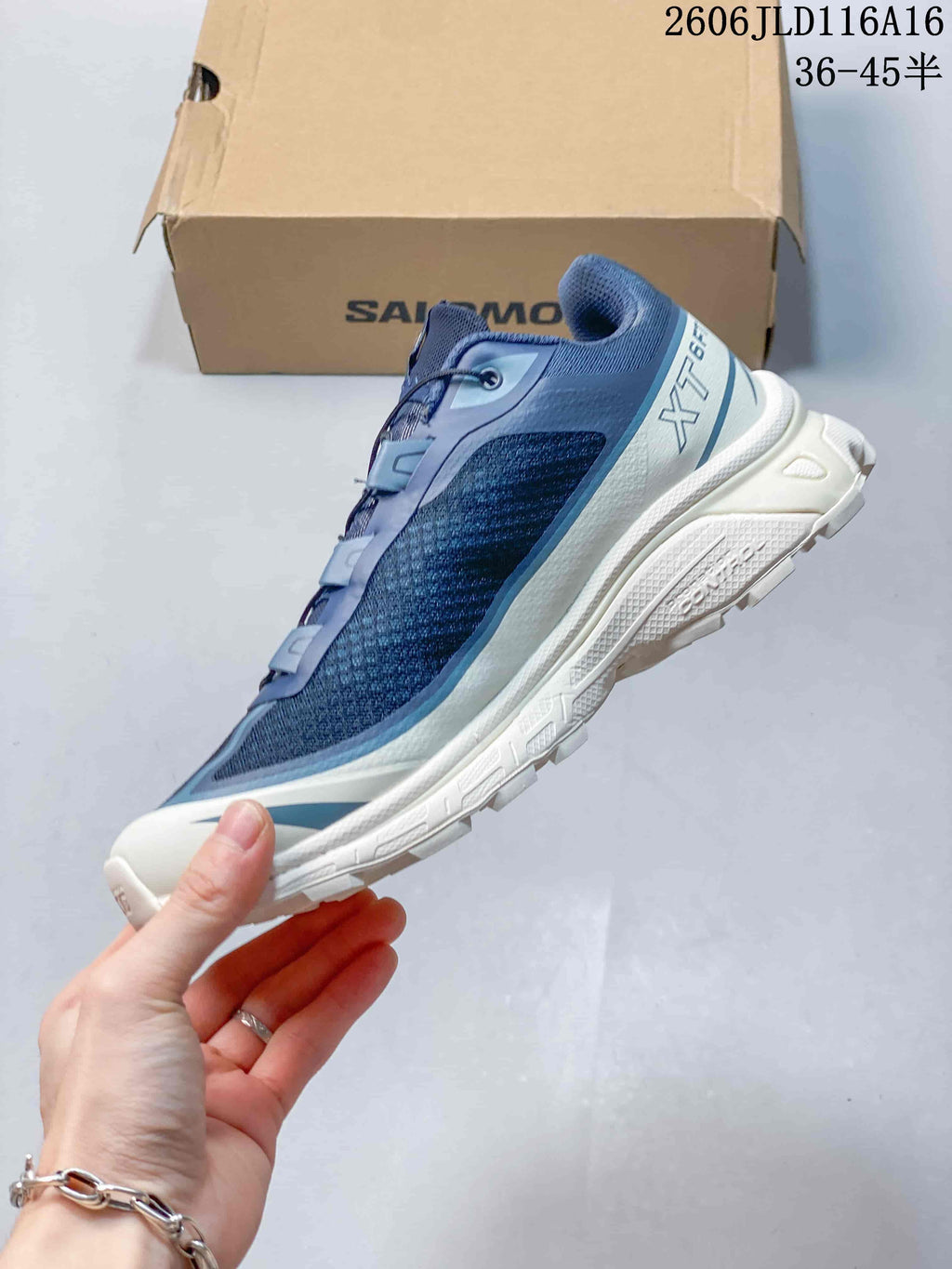 Side profile of the blue sneaker with layered panels and white sole