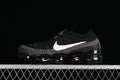 Black Nike Air VaporMax 2023 Flyknit sneaker with white Swoosh and multicolor knit accents, side view