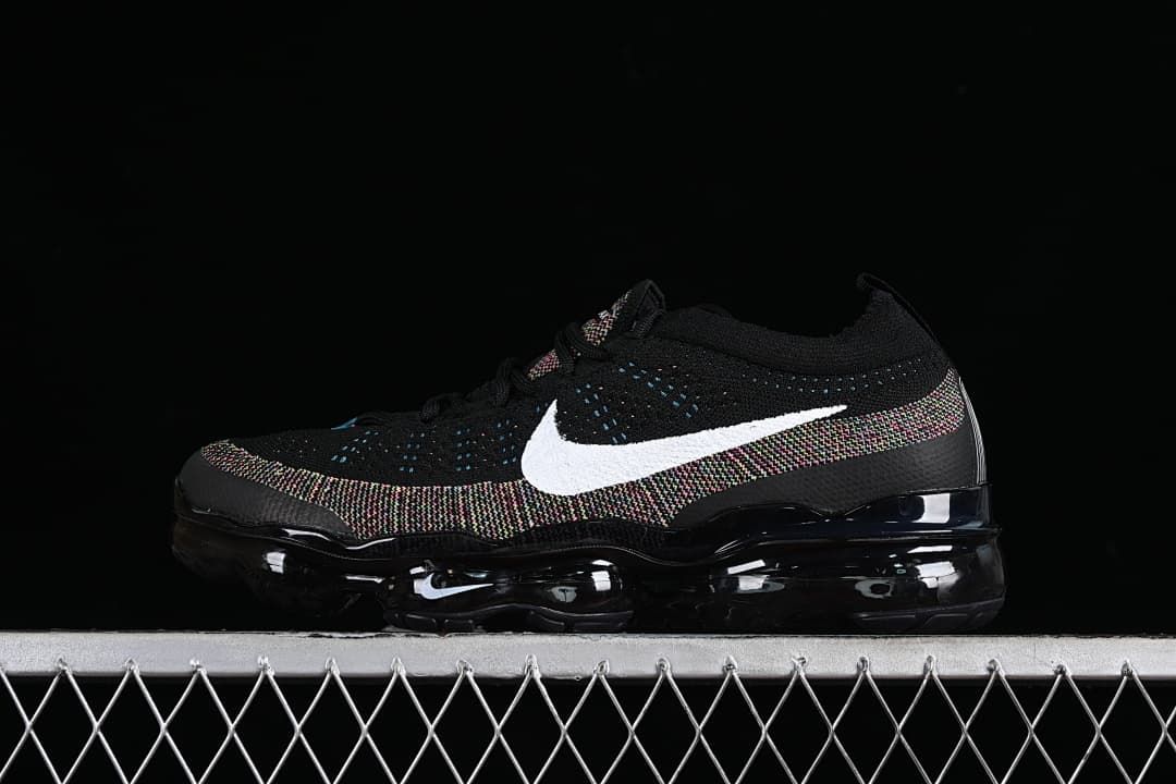 Black Nike Air VaporMax 2023 Flyknit sneaker with white Swoosh and multicolor knit accents, side view