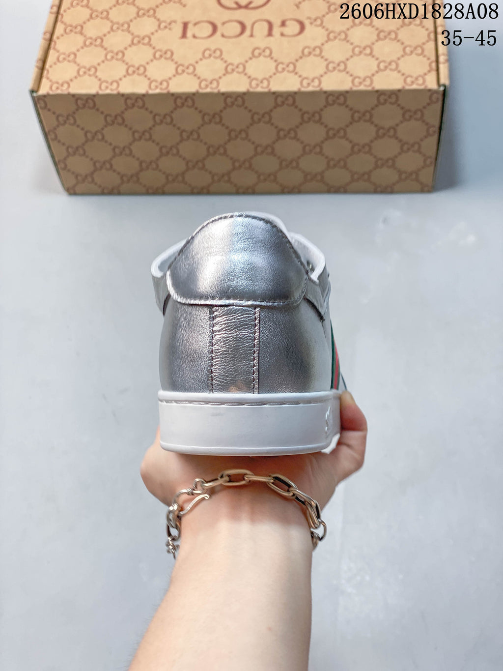 Rear view of a silver sneaker showing the heel panel and white sole.