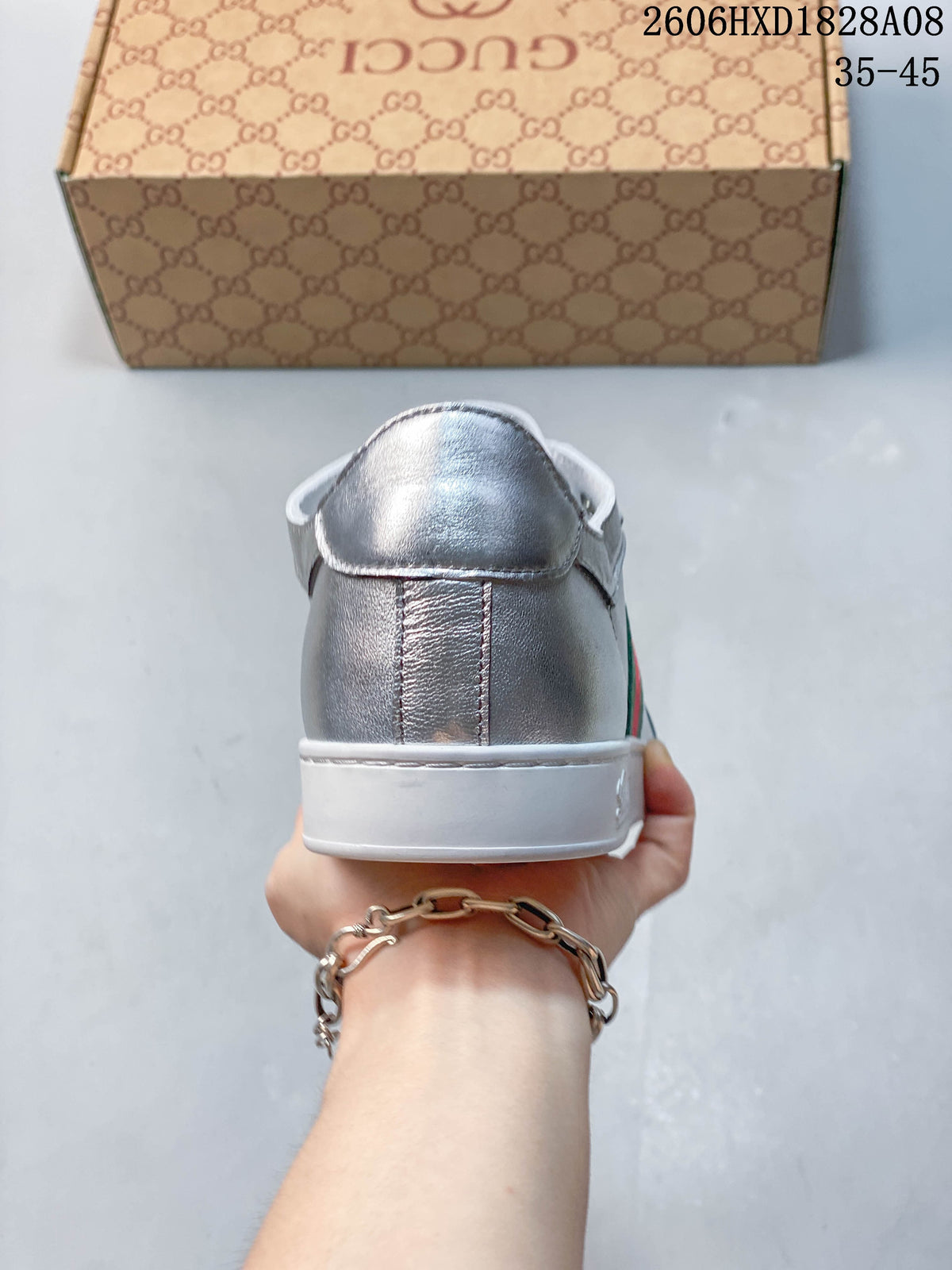Rear view of a silver sneaker showing the heel panel and white sole.
