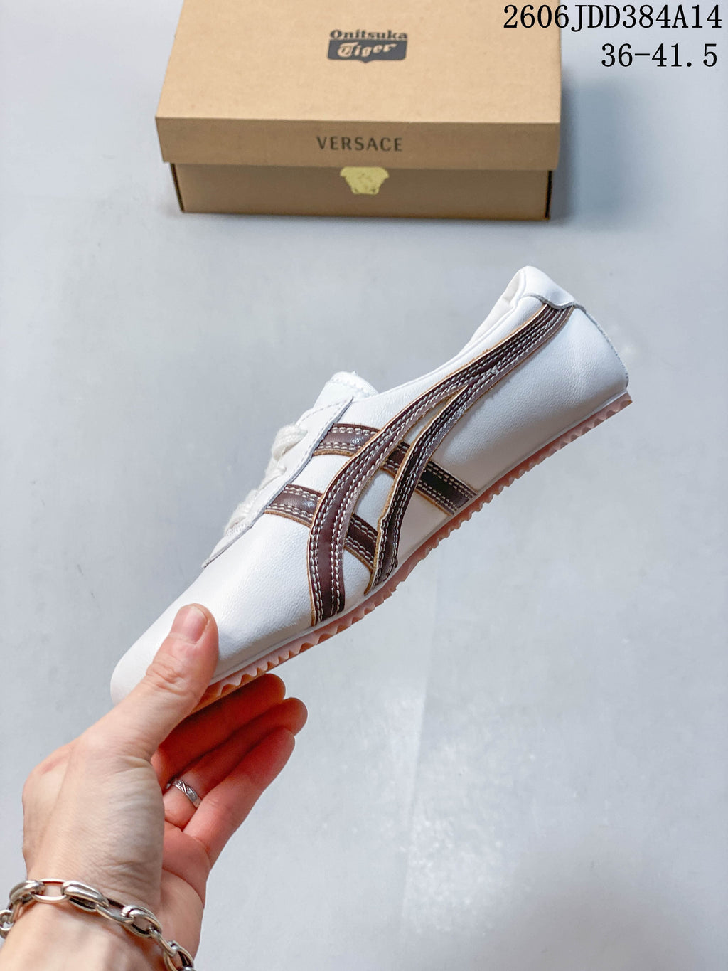 Side view of the white low-top sneaker with brown stripes