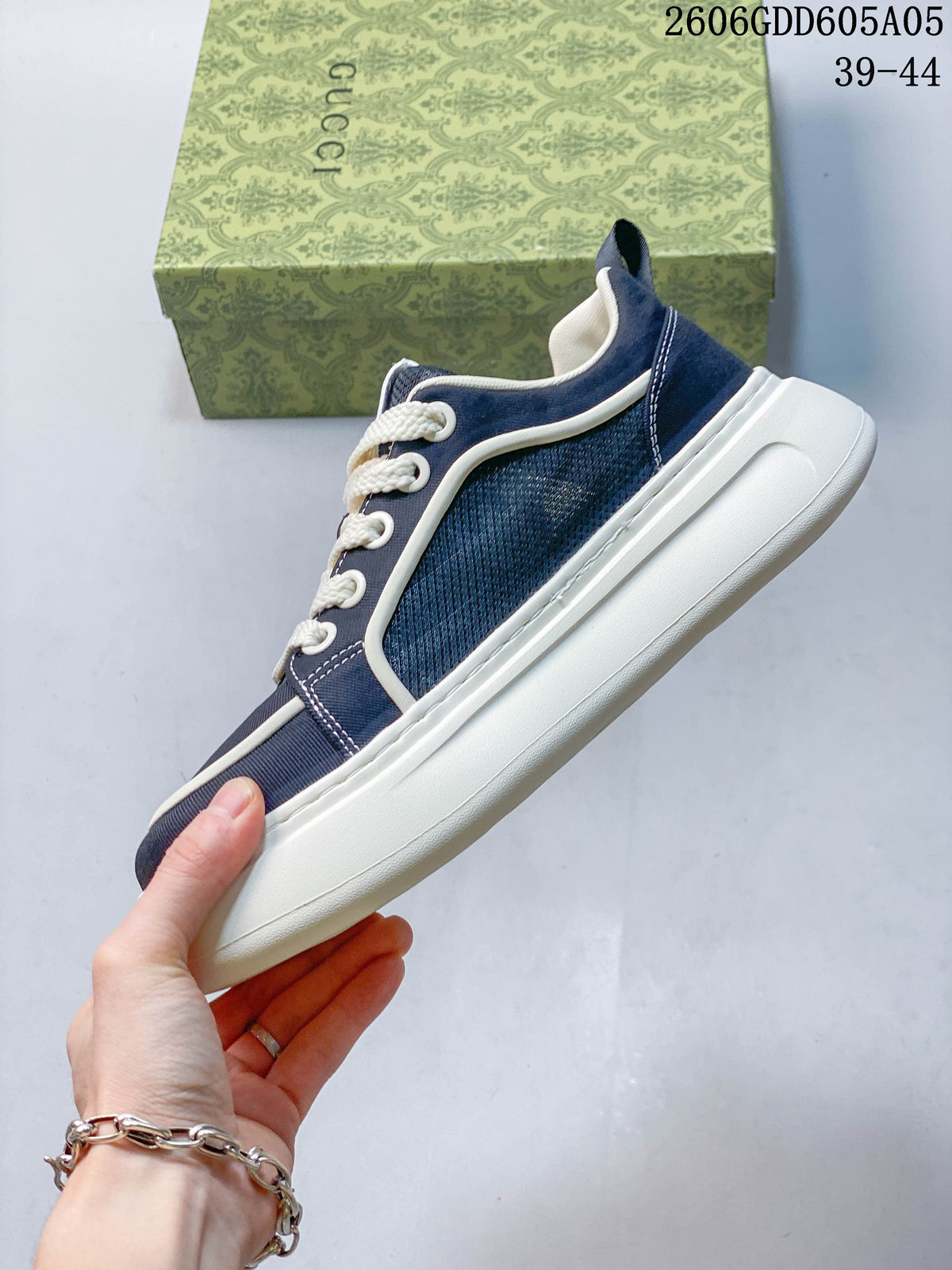 Side profile of a navy sneaker with textured panels, white trim, and a thick sole