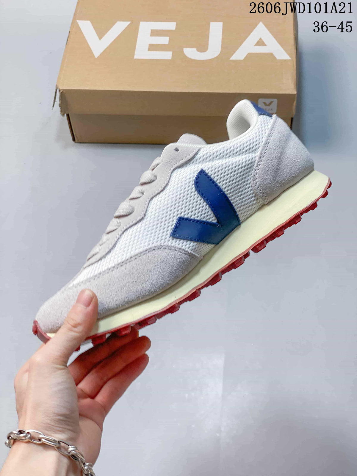Side view showing the blue V-shaped logo, light gray overlays, and cream-colored midsole