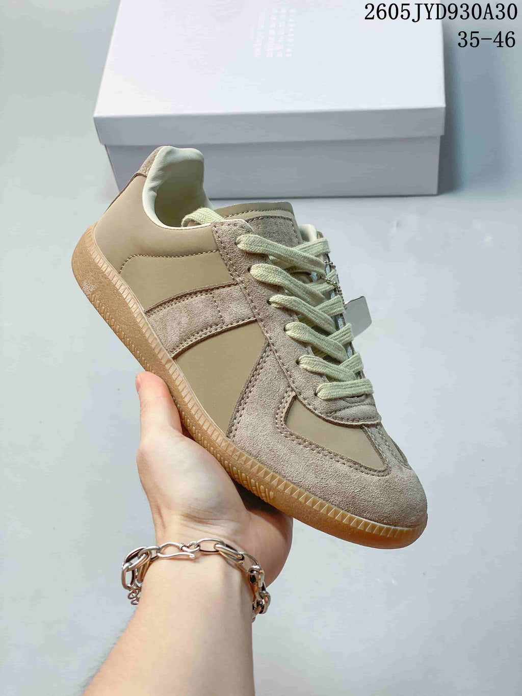 Angled side view of the taupe low-top sneaker with pale laces and gum sole.