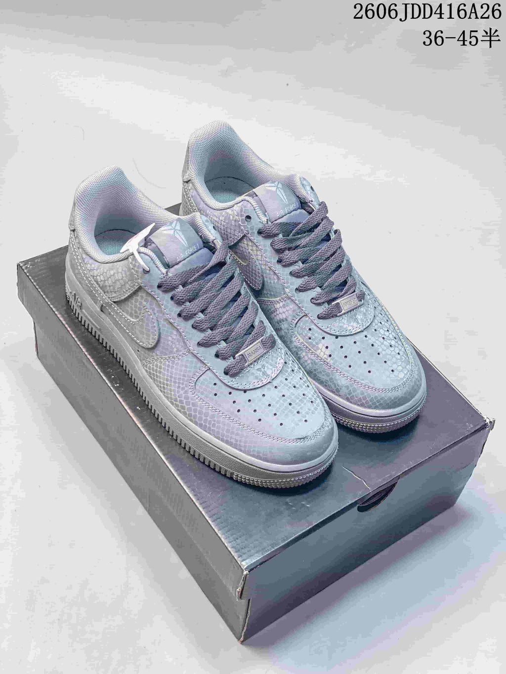 Pair of gray-toned low-top Nike Air Force 1 '07 sneakers with a repeating textured pattern.