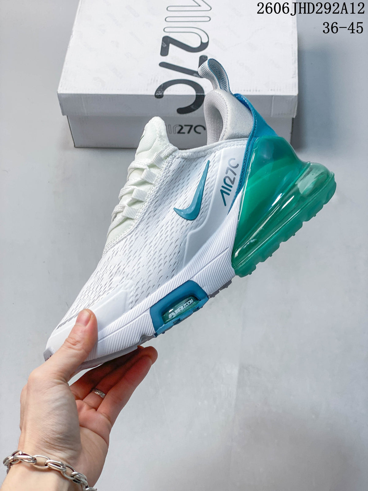 Side view of a white Nike Air Max 270 sneaker with green and blue accents