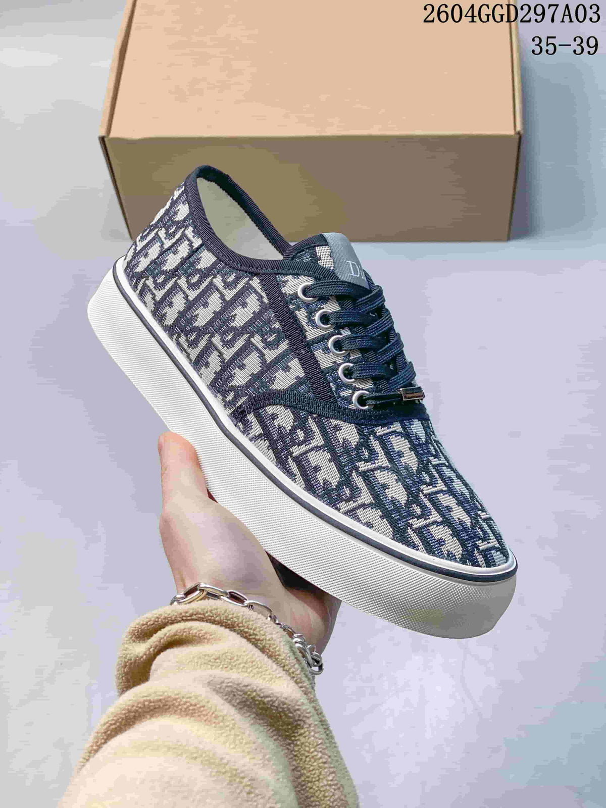 Angled view of the navy monogram sneaker with dark laces and white sole