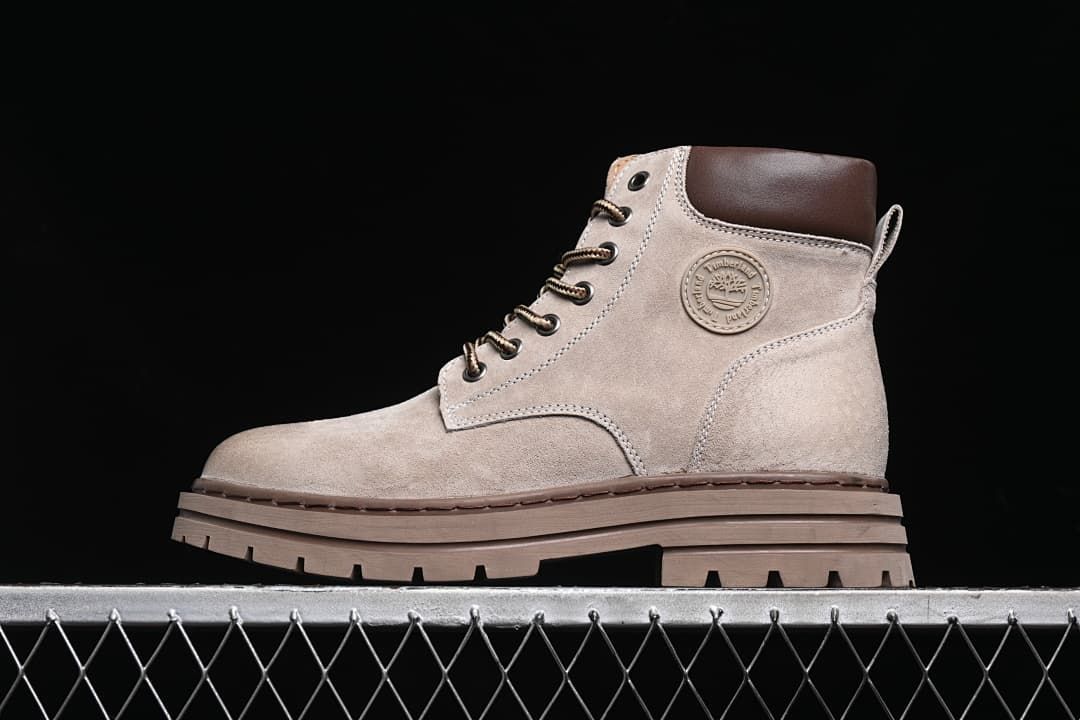 Side view of a sand-colored Timberland high-top boot with a brown collar and chunky lugged sole