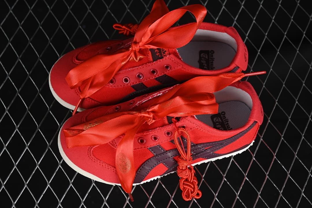 Pair of red kids’ sneakers with ribbon and cord laces