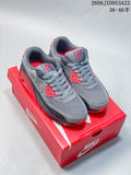 Gray and red Nike Air Max 90 sneakers displayed on a red Nike shoe box