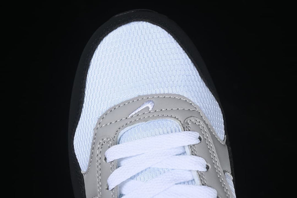 Top-down view of the white mesh toe, grey overlays, and white laces.