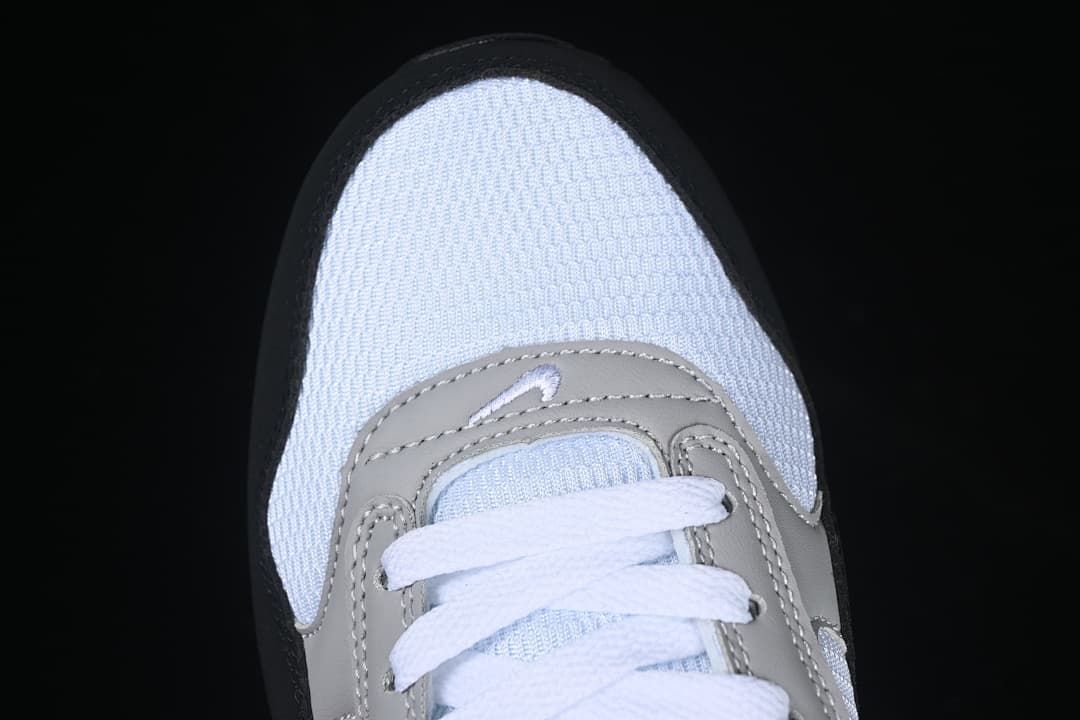 Top-down view of the white mesh toe, grey overlays, and white laces.