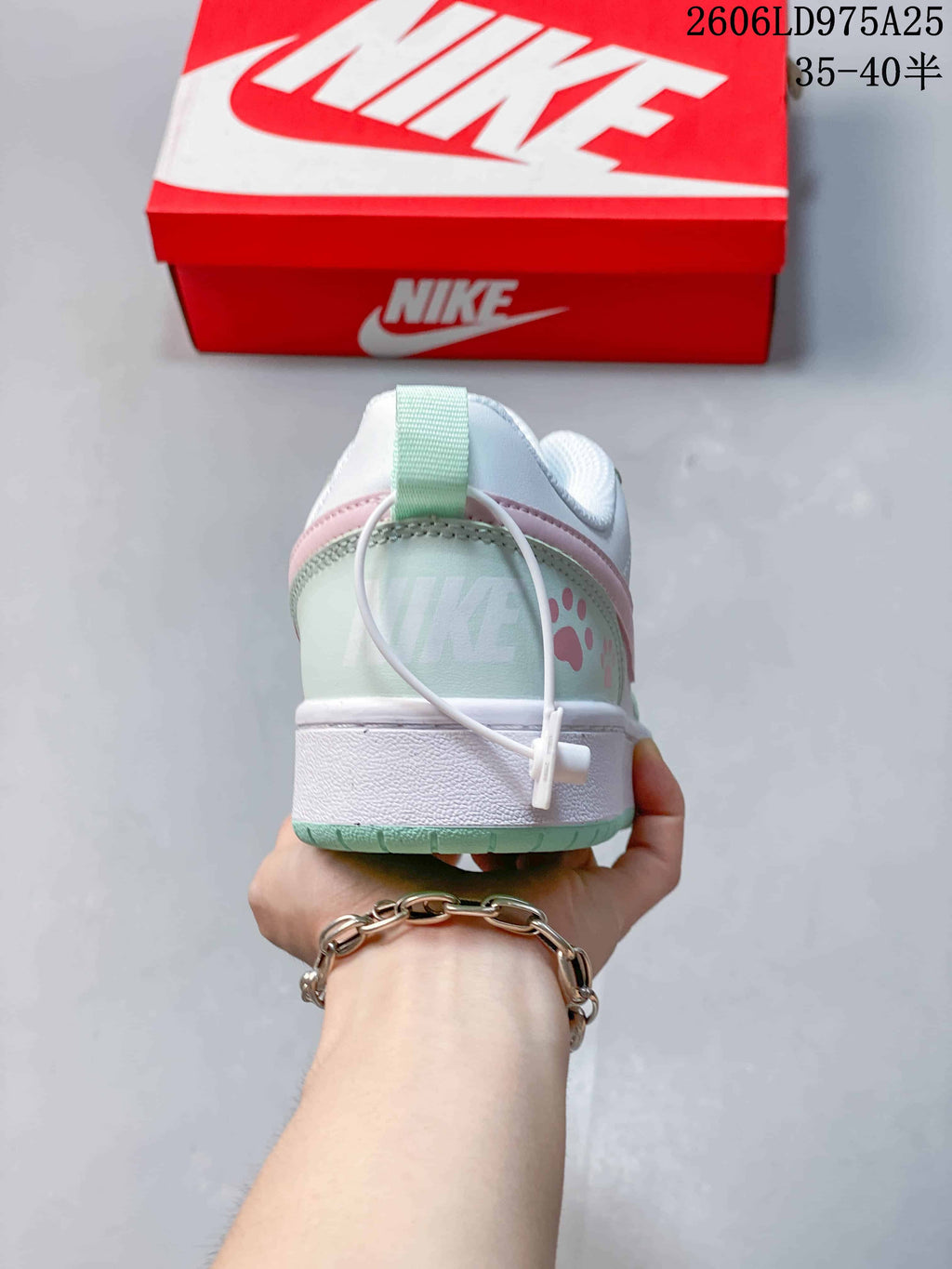 Rear view of a Nike Court Borough Low sneaker with mint and pink details.