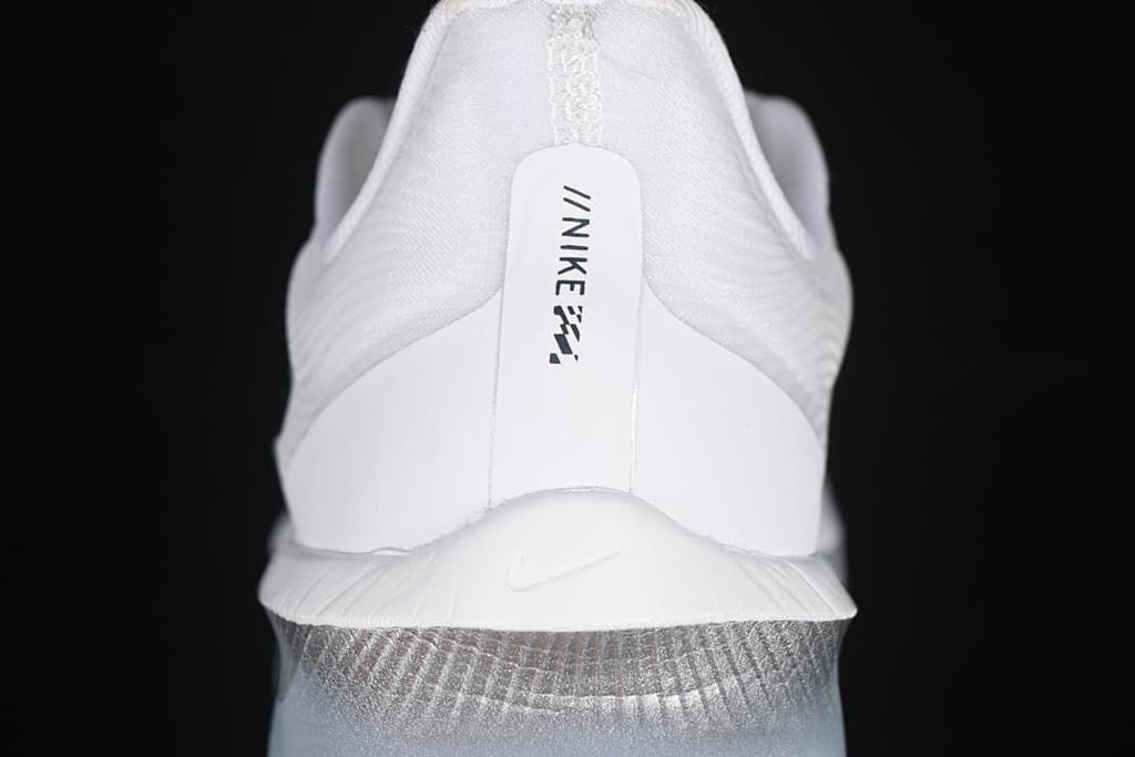 Rear view of the white shoe with Nike branding and a gray-blue midsole.