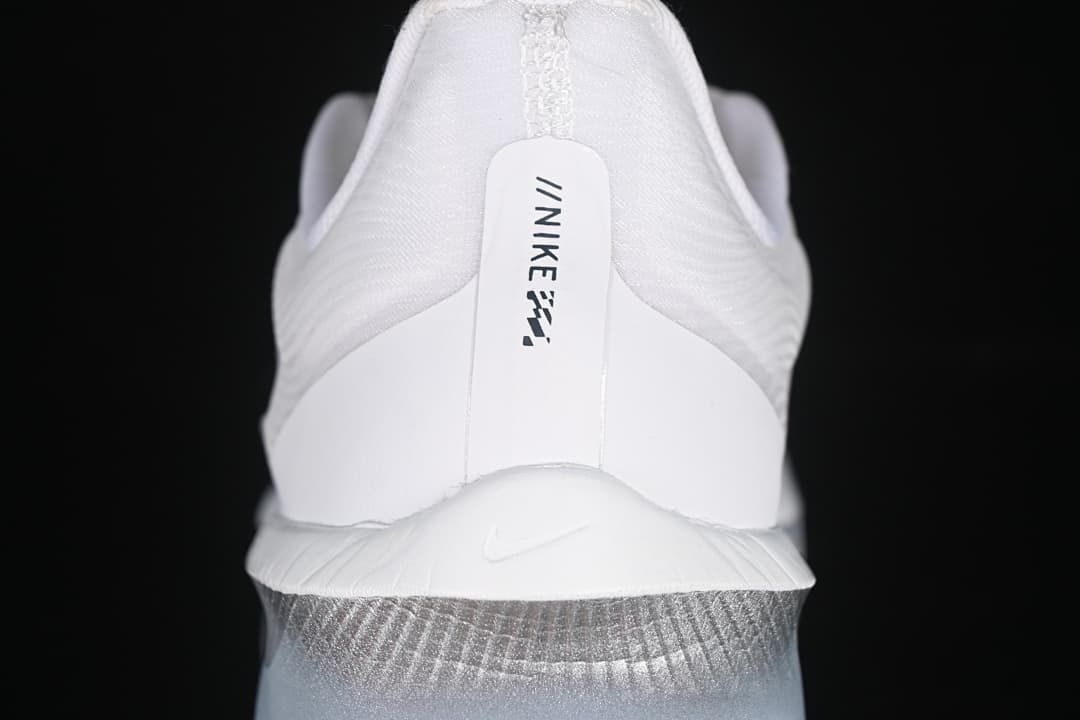 Rear view of the white shoe with Nike branding and a gray-blue midsole.