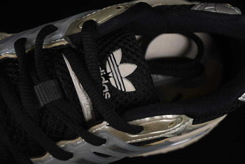 Close-up of black laces, tongue and trefoil logo