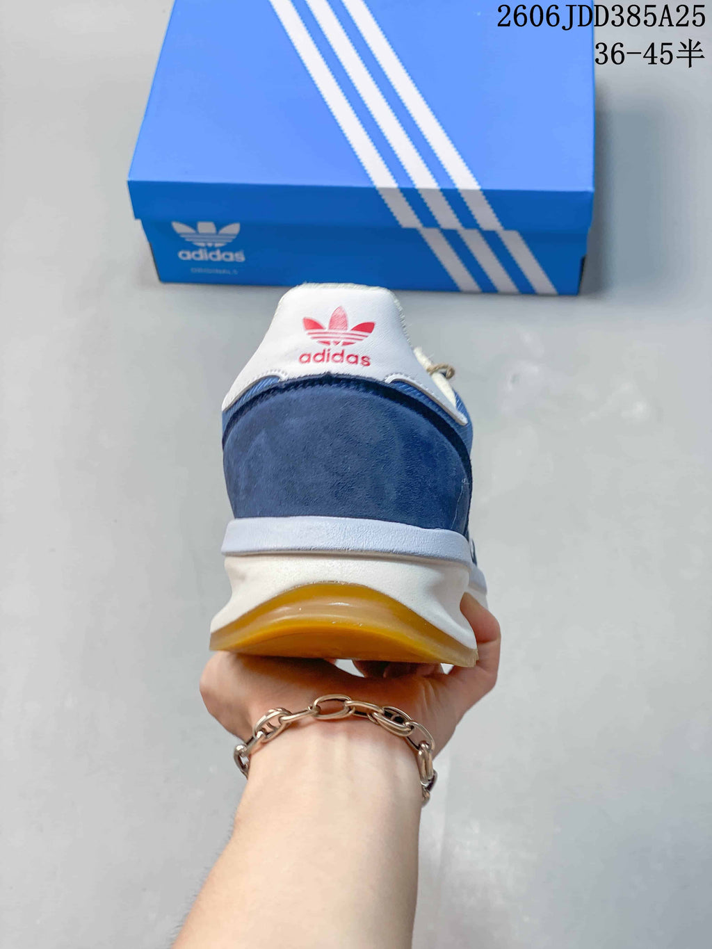 Rear view showing the navy heel panel, white heel tab, and gum-colored outsole.