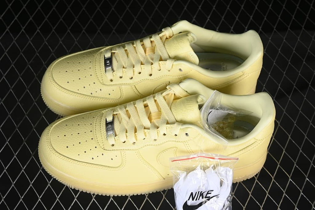 Pair of pale yellow low-top sneakers with an additional lace set pictured