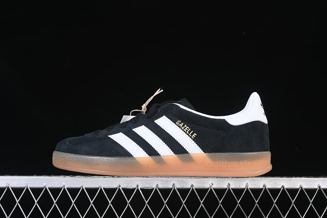 Side view of a black and white adidas Gazelle Indoor sneaker with a gum-colored sole.