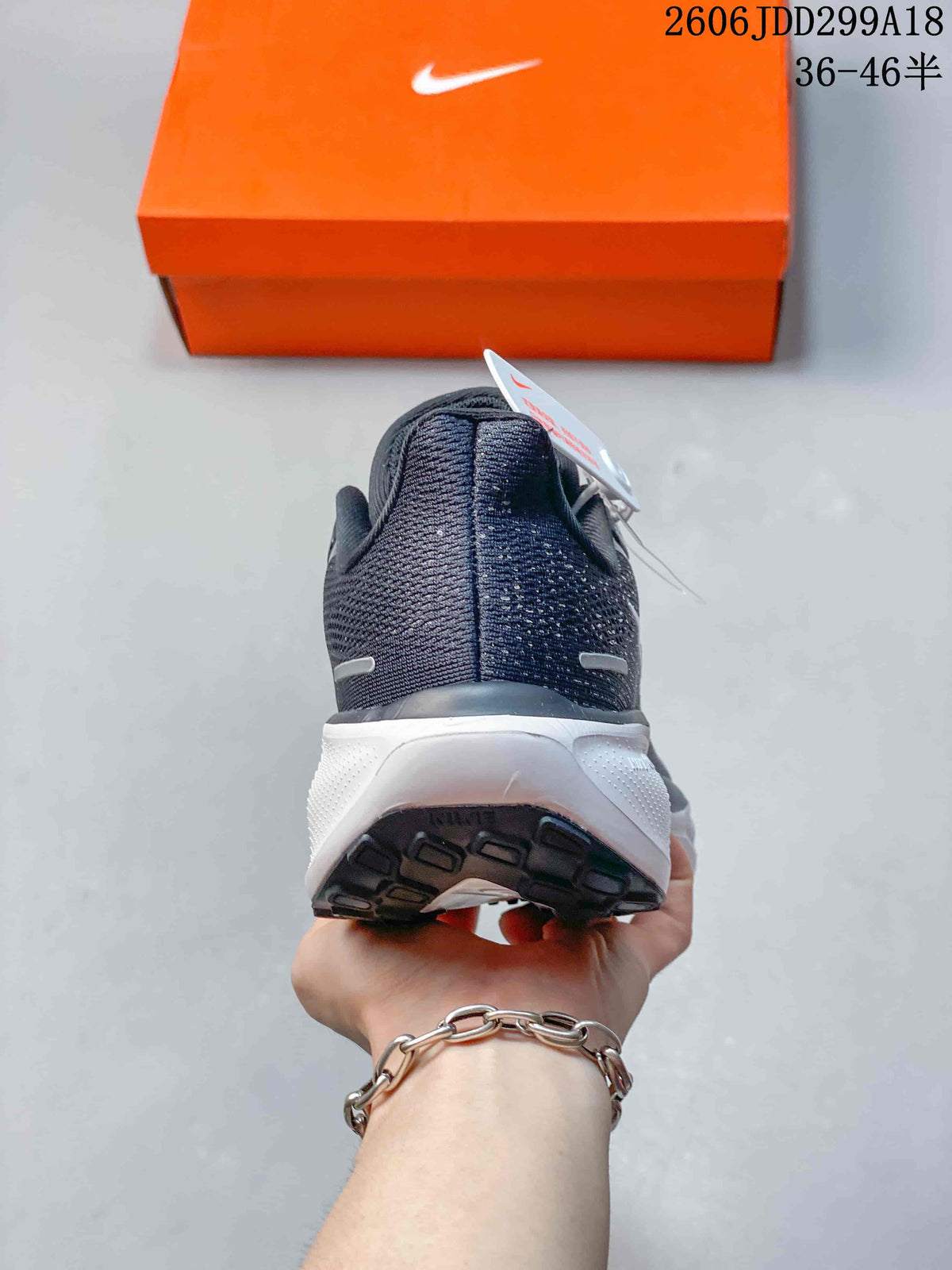 Rear view of a dark gray Nike running shoe with a white midsole