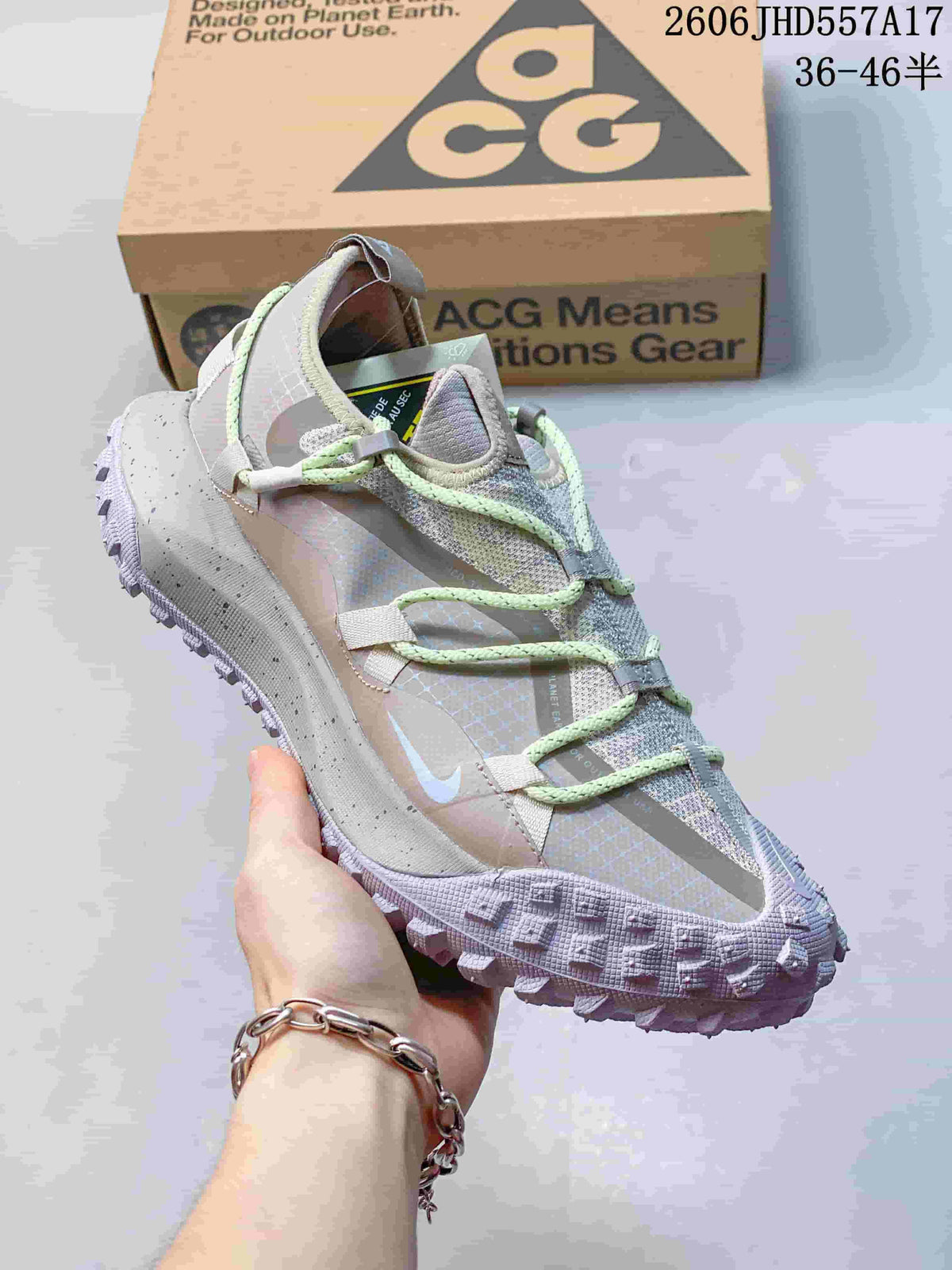 Close side view of the sneaker with its pale gray upper, mint-green laces, and textured outsole.