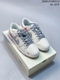 Pair of cream and grey Nike Dunk Low-style sneakers with grey laces and red accents