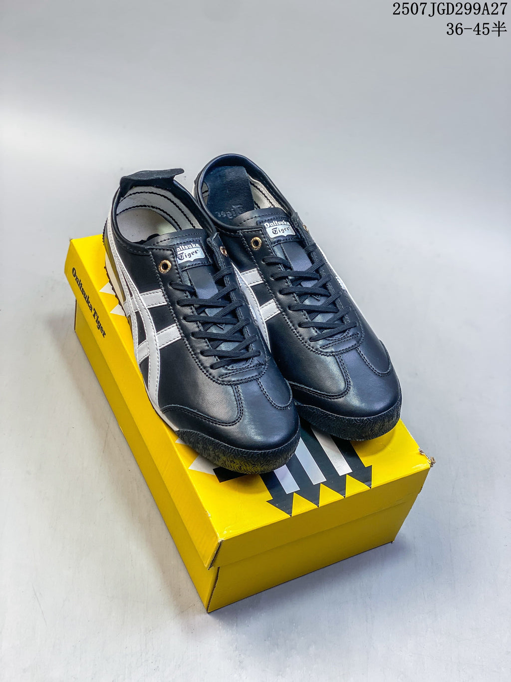Black and silver Onitsuka Tiger Mexico 66 SD Paraty sneakers displayed on a yellow shoebox