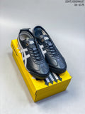 Black and silver Onitsuka Tiger Mexico 66 SD Paraty sneakers displayed on a yellow shoebox