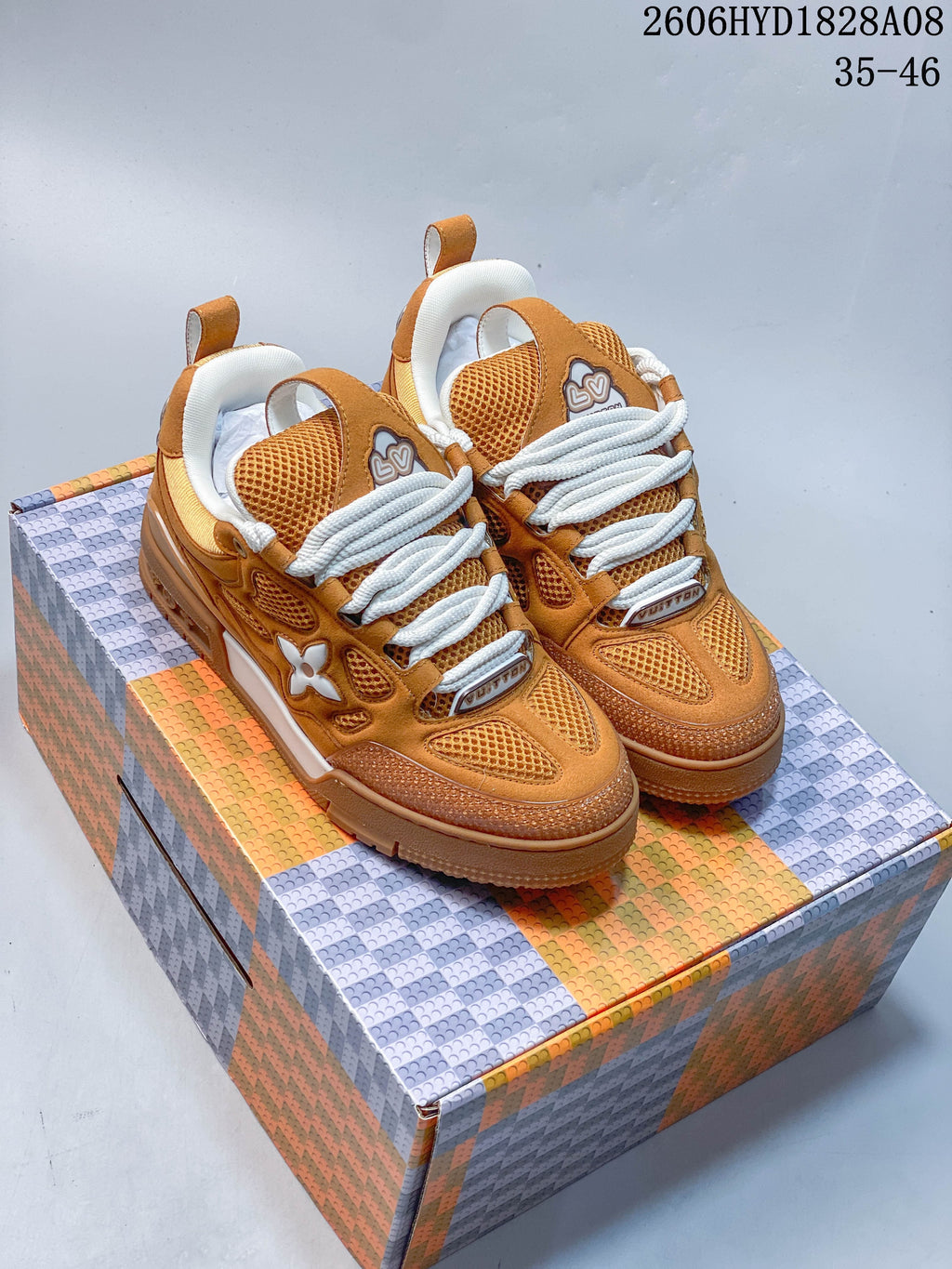 Pair of orange low-top sneakers with mesh panels, thick laces, and gum-style outsoles.