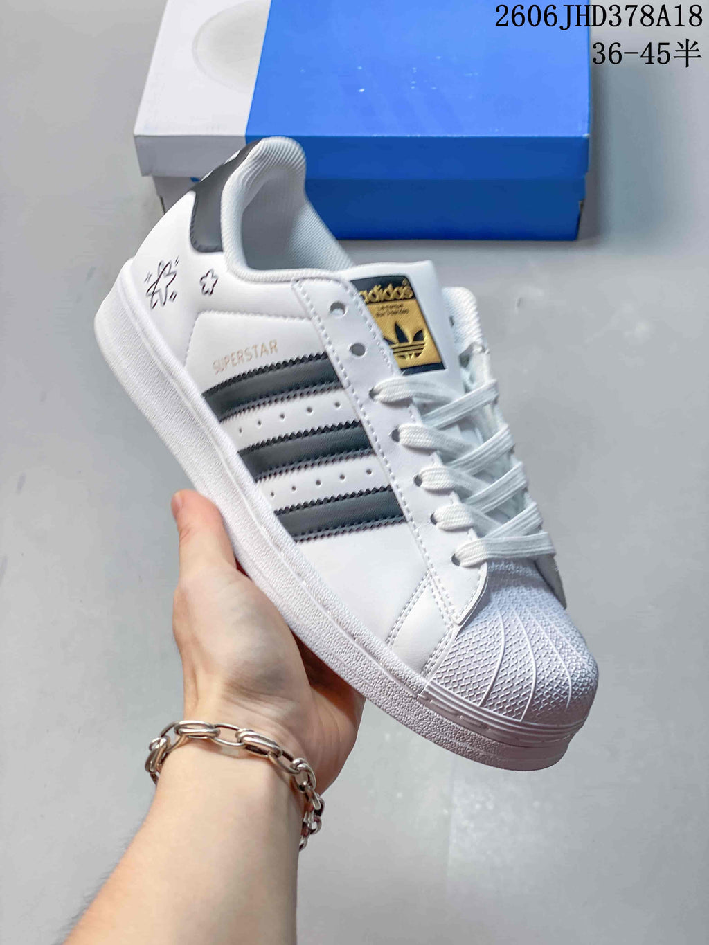 Angled side view of the sneaker with Superstar lettering and dark stripes