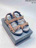 Pair of brown and gray ECCO open-toe sandals with adjustable straps displayed on a box.