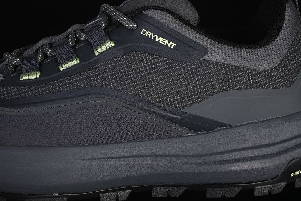 Close-up of the dark gray upper, lace eyelets, and printed branding