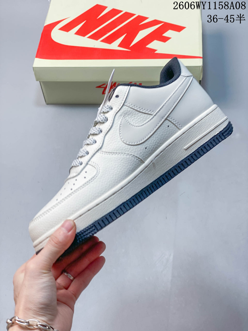 Side view of the pale low-top sneaker with a tonal side swoosh and navy outsole.