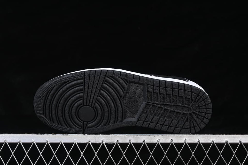 View of the black outsole with circular forefoot and linear tread patterns.