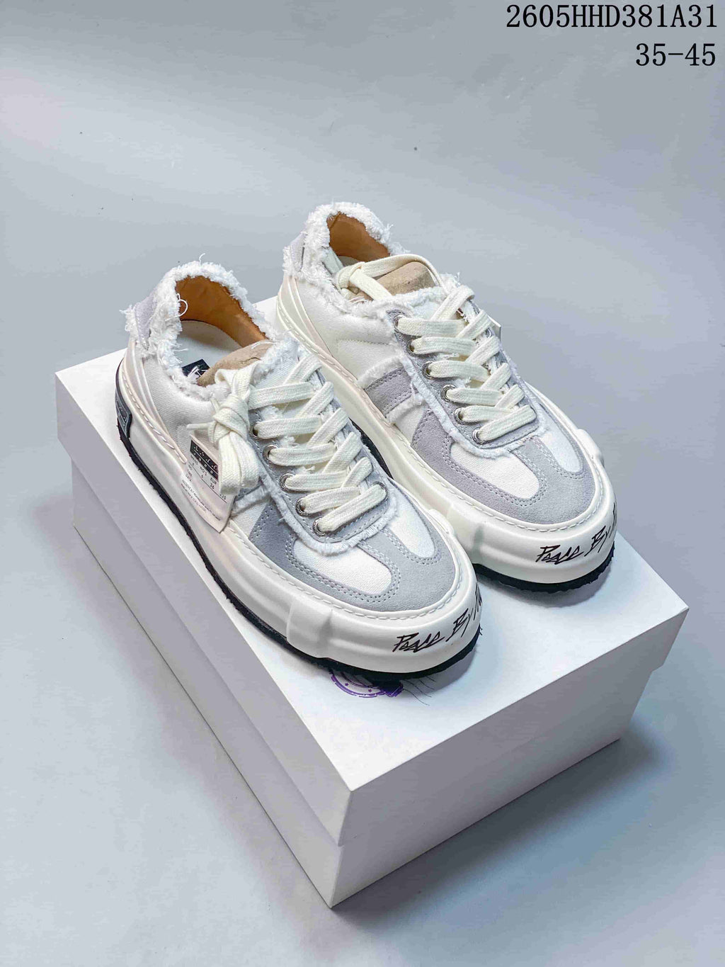 Pair of white and gray xVESSEL G.O.P. Low sneakers with frayed collar trim and thick soles