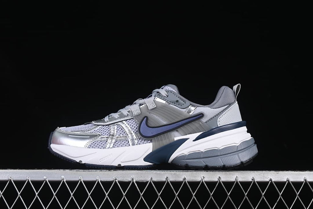 Side view of a silver and gray Nike V2K Run sneaker with navy accents
