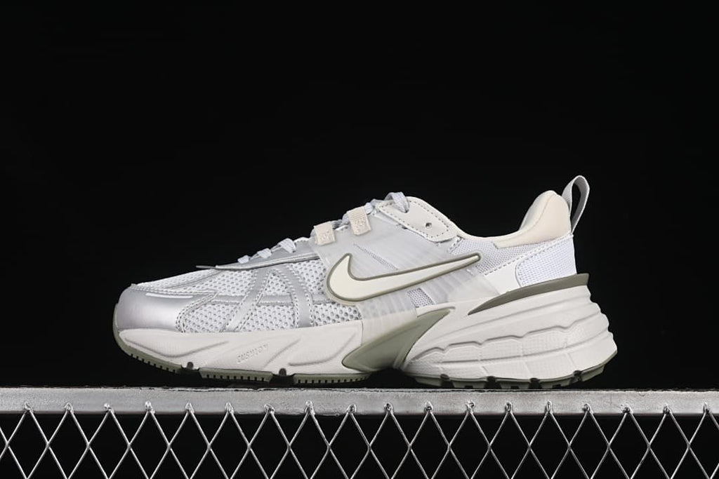 Side view of a white and light grey Nike V2K Run sneaker with muted olive accents