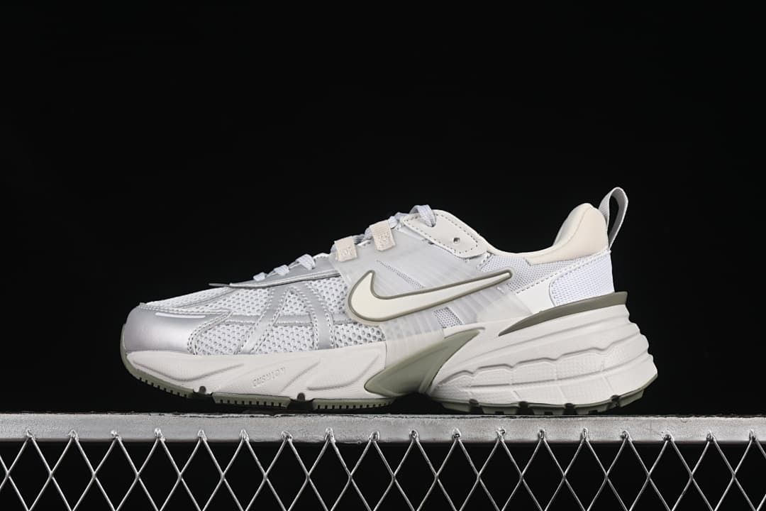 Side view of a white and light grey Nike V2K Run sneaker with muted olive accents