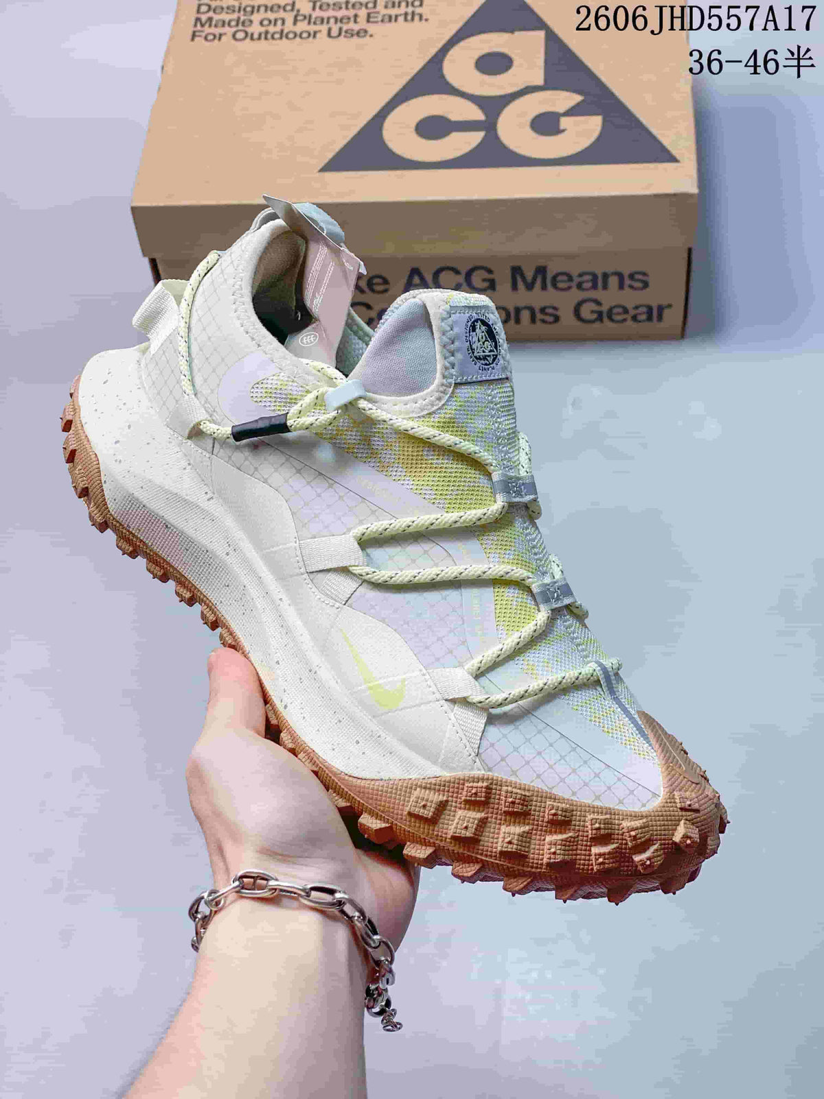 Nike ACG Mountain Fly sneaker in pale tones with yellow-green accents and a rugged outsole.