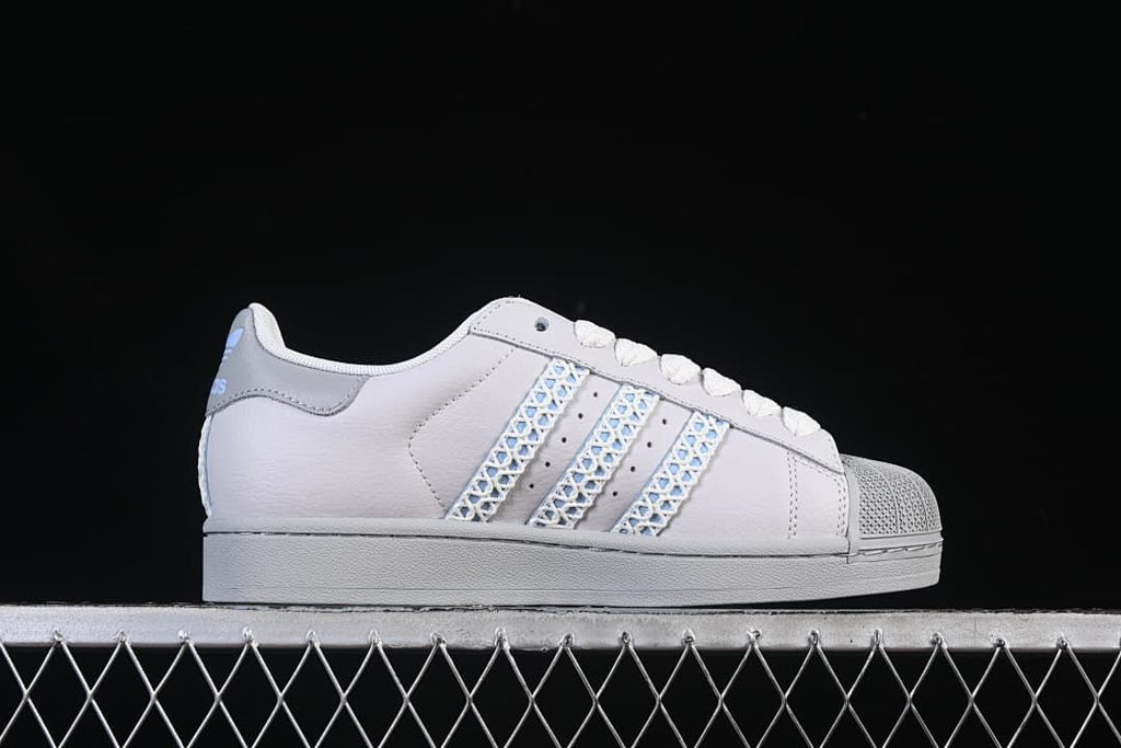 Side profile highlighting the low-top shape, pale blue patterned stripes and grey sole.