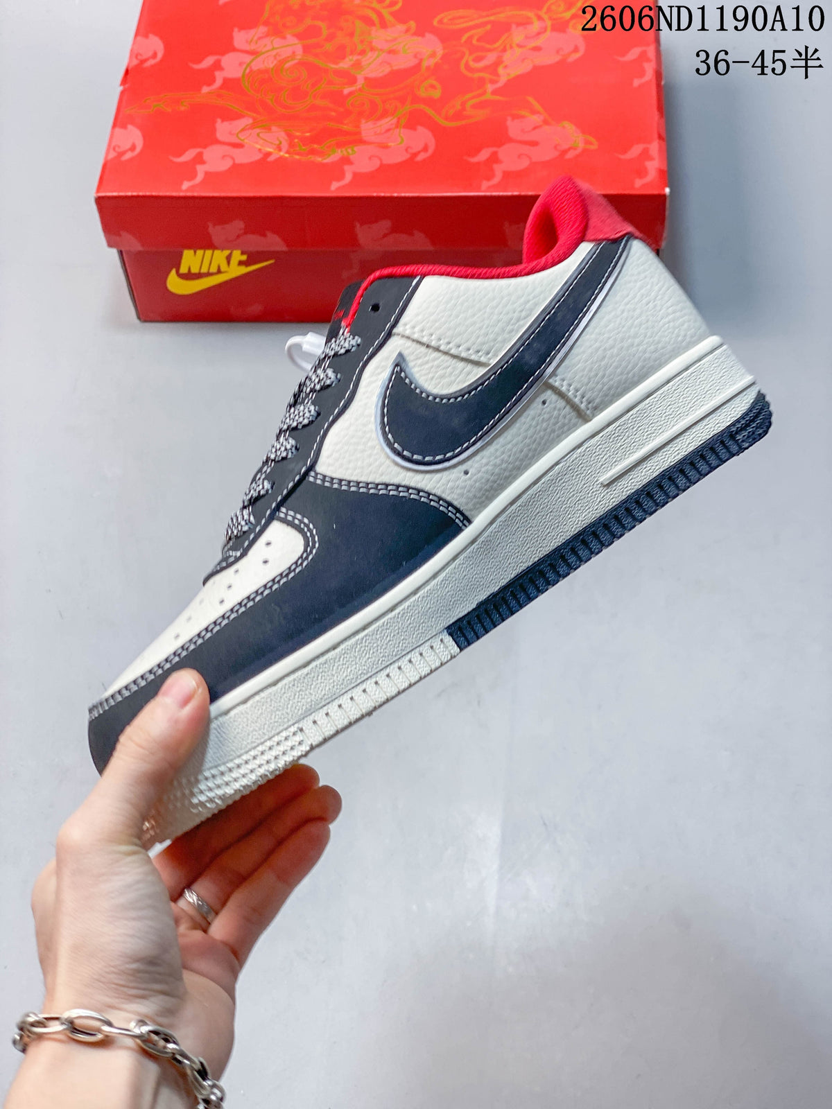 Side view of the white and navy sneaker with red collar accents