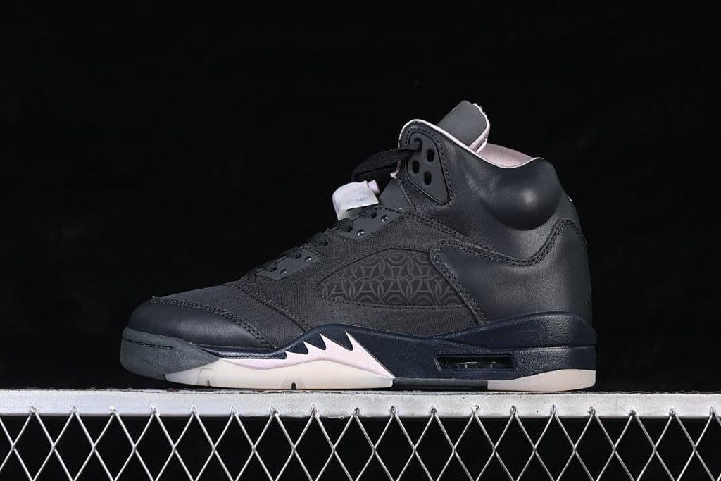 Side view of a black Air Jordan 5 Retro PSG sneaker with pale pink and light-colored sole accents
